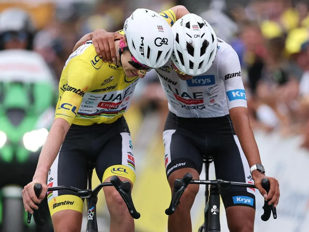 UAE Team Emirates - XRG's Slovenian rider Tadej Pogacar wearing the overall leader's yellow jersey and UAE Team Emirates - XRG's Mexican rider Isaac Del Toro wearing the best young rider's white jersey celebrate as they cross the finish line of the 20th stage of the 113th edition of the Tour de France cycling race, 170,9 km between Le Bourg-d'Oisans and Alpe d'Huez in the French Alps, on July 25, 2026. (Photo by Anne-Christine POUJOULAT / AFP)